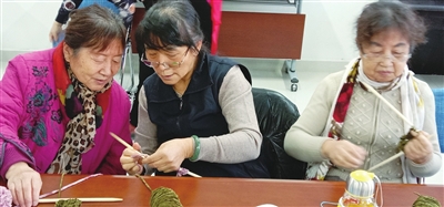 <p>　　银川老年大学手工班学员们互相交流围巾编织技巧。</p>