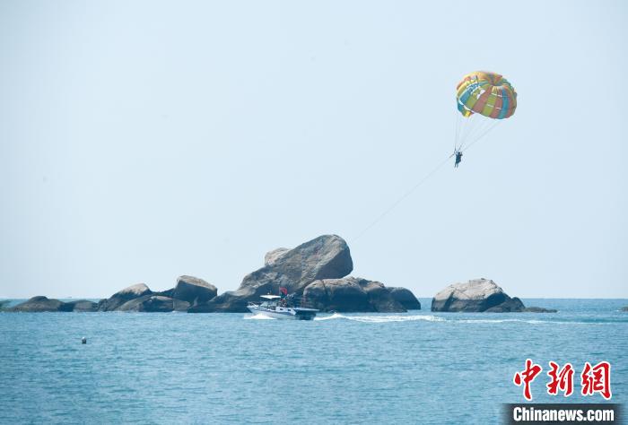大年初一，游客在天涯海角游览区体验海上拖伞项目。　游必生 摄