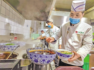 <p>　　李飞龙（前）与员工一起制作牛肉拉面。</p>