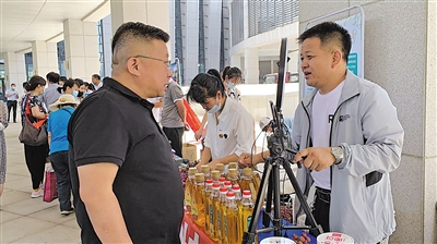 <p>　　张亚东（右）给顾客介绍亚麻籽油。</p>