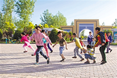 <p>　　2018年5月19日，中卫市沙坡头区迎水桥镇鸣沙移民新村广场上，孩子们在嬉戏。　马德　摄</p>