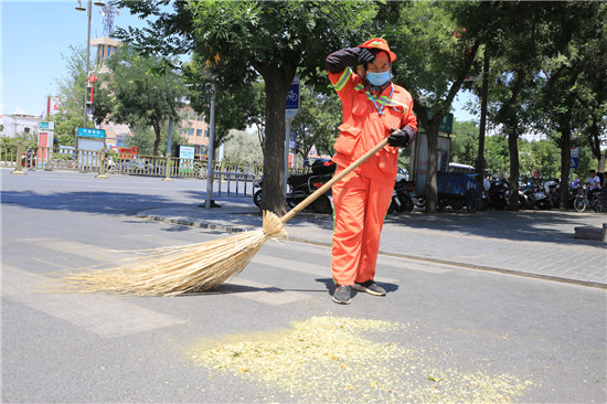 7月19日,在利通街,一名环卫工人正在擦汗,无论是严寒酷暑,他们永远