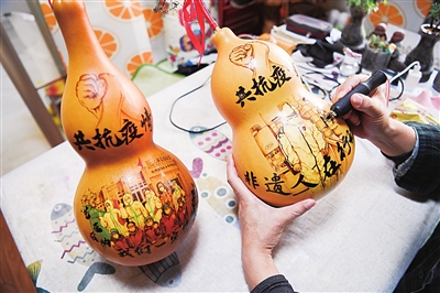 陈湘军正在葫芦上烙画。