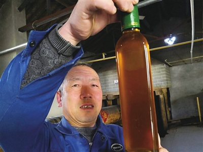     工人展示纯手工胡麻油。