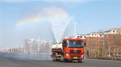 <p>　　装满消毒水的洒水车在天空中喷出一道亮丽的彩虹。</p>