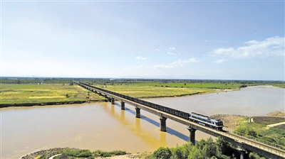 <p>→中铁一局新运机车牵引煤炭列车驶过黄河大桥。</p><p>（图片由受访单位提供）　</p>