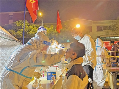 <p>医护人员正在为居民进行咽拭子采样。　本报记者　李涛　摄</p>
