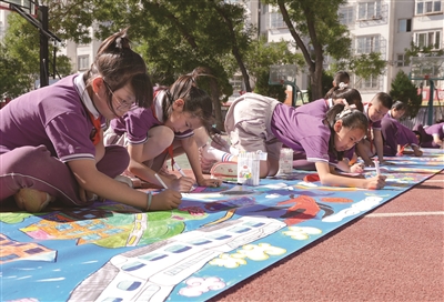 银川市二十一小鼓楼分校学生在百米长卷上绘画。兴庆区融媒体中心供图