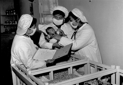 <p>　　1959年3月，　银川市人民医院妇产科的大夫和助产士一起检查早产婴儿。</p><p>　　买世杰　摄</p>
