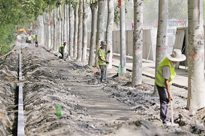 <p>　　8月16日，银川市兴庆区凤凰南街（宝湖路—长城路）西侧，工人正在进行慢行绿道建设。银川市以治理“城市病”为核心，目前启动城市更新三年行动，通过补短板、提质效，对现有城区“软硬件”进行整体提升，不断保持城市活力和竞争力。						　　本报记者　党硕　摄</p>