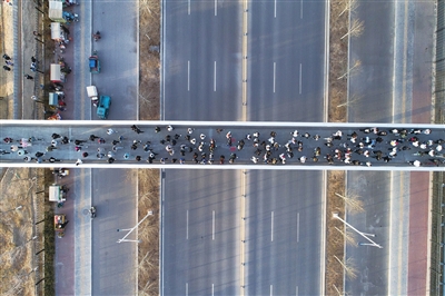 3月1日，在银川市西夏区宁朔街北方民族大学新老校区过街天桥上，学生们走在上学的路上。因上下学集中，这条过街天桥被网友们称为“最美上学路”。　本报记者   季正    摄