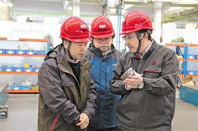 <p>新当选的中国工程院院士马玉山（右一）和科研团队在生产车间探讨新技术问题。</p><p>（图片由受访者提供）</p>