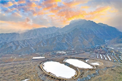 <p>　　落日余晖映红了天空，贺兰山脚下的两个大型防火蓄水池上积雪静卧冰面，相映成景。</p>