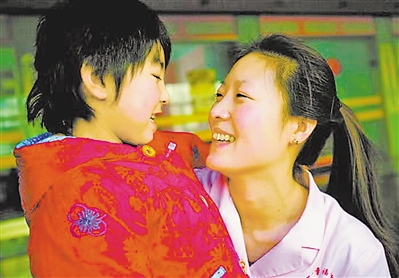<p>　　2012年，李华芳悉心照看福利院的孩子。（资料图片）</p>