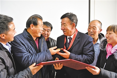 <p>　　　　2018年12月18日，庆祝改革开放40周年大会在北京人民大会堂举行。100名为改革开放作出杰出贡献的个人被授予“改革先锋”称号，王有德成为宁夏唯一入选人物。当年12月20日，王有德回到灵武市，与同事们一起分享这份荣耀。　　　　	　			　　　　　　　　　本报记者　王鼎　摄</p>