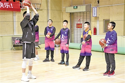     专业教练员走进银川湖滨体育馆指导学生投篮。
