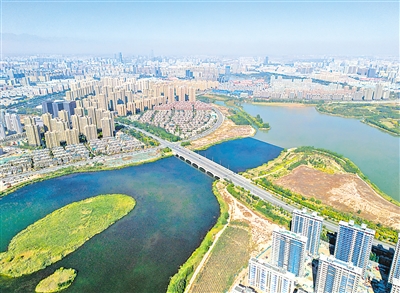     2022年10月11日，俯瞰六盘山路，波光潋滟的七子湖如蓝色飘带向城市延伸，昔日荒地已是高楼林立，展现出美轮美奂的湖城意境。