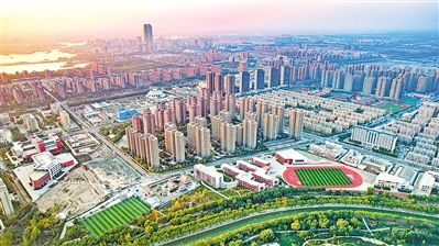 秋日夕阳印染下，鳞次栉比的住宅楼被镀上一层暖色，小区周边学校、商超、公园等基础配套设施齐全，一派安居乐业的景象。