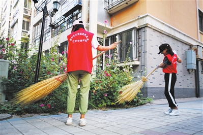     金凤区新昌西路榕安苑小区内，志愿者在维护小区环境卫生。　@雨荷心 摄