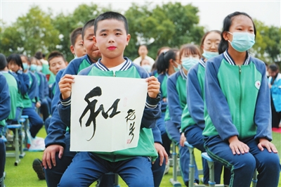 一名学生展示得到的书法作品。本报记者　闵良　摄