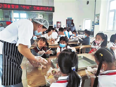 北师大银川学校小学部一年级的学生跟着老师学做月饼。