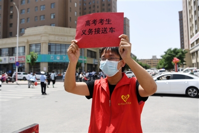     志愿者守候在考点外义务接送考生。