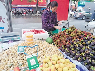 <p>　　小鲁正在给顾客装水果。二维码成了她收款的好帮手。</p>