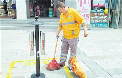 <p>　　环卫工人拜立根在清扫路面。　　　　　　　　　　　　　　　　　　　　　　　本报记者　陶涛　摄</p>