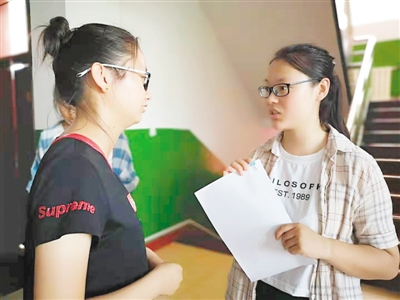 <p>　　陈静（右）为申请助学贷款的大学生讲解注意事项。</p>