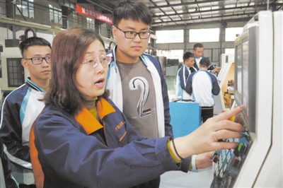<p>　　杨秀琴在实训车间给学生讲授数控机床的技术要点。</p>
