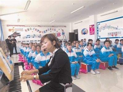 <p>　　林晓燕边弹琴边教学生唱歌。</p>