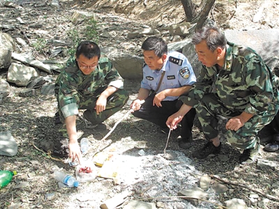 <p>　　吴涛（左一）和森林公安民警、护林员巡查时发现了疑似盗猎分子在山里留下的痕迹。（受访者供图）　</p>