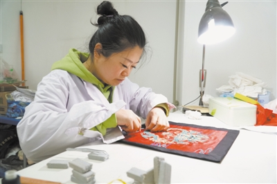 <p>　　杨丽蔚在修复龙纹图案座垫。</p>