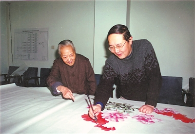 <p>　　1999年，曾杏绯在指导马建军作画。　　　　　　　　　　　　（图片由马建军提供）</p>