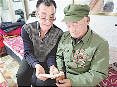 <p>　　翻开相册，马洪有和儿子分享当年在部队的故事。</p>