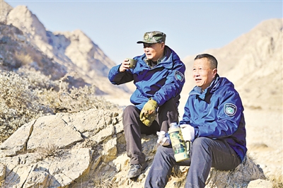 <p>　　下午3点，查山工作结束，张玉亮（右）和张玉明坐在沟边的大石头上喝口热水。</p>