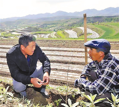 <p>　　郭利平（左）给村民讲解藜麦种植技术。</p>