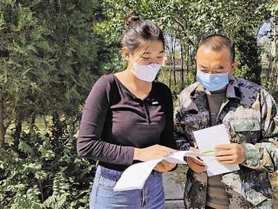 邱佳霖向群众讲解政策。<br/>　　本报记者 李锦 摄