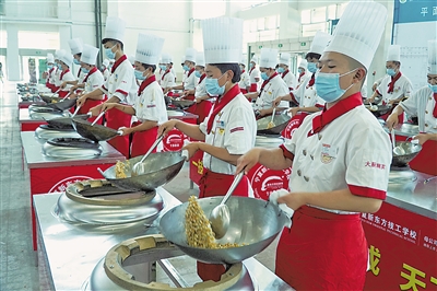     烹饪专业职校生在认真学习烹饪技能。