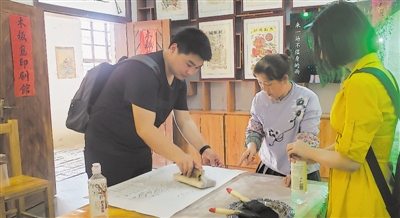 <p>　　游客体验木版年画拓印。</p><p>　　本报记者　张唯　摄</p>
