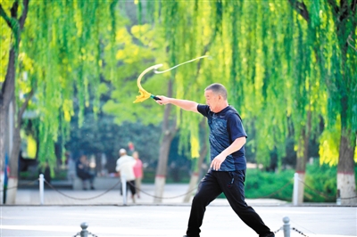 <p>　　晚饭后，一位市民用力挥动鞭子，健身方式各取所需。</p>