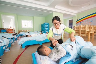 <p>　　孙银霞老师给午睡的孩子盖好被子。</p>