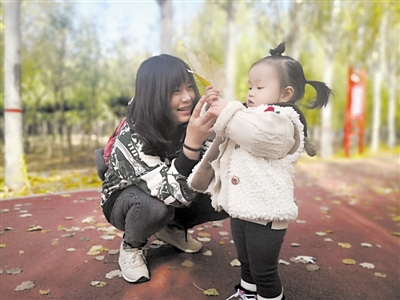 <p>　　王女士带着女儿认识树叶。　　　　　　　　　　　　　　　　　　　　　　　　本报记者　徐佳敏　摄</p>