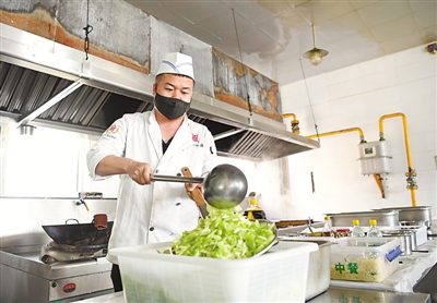 <p>　　在银川一中，厨师按要求佩戴口罩为学生准备午餐。</p>