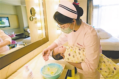 <p>母婴护理员在给婴儿洗头。</p>
