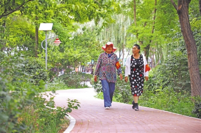 <p>　　居民在改造后的吴忠市地税局小区里散步。</p>