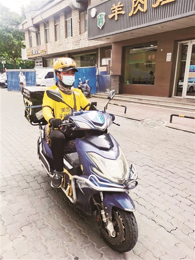 杨晓龙骑电动车为客户送餐。