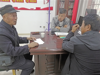 青铜峡市峡口镇谭桥村党支部书记杨军（中）调解群众的土地纠纷。（资料图片）