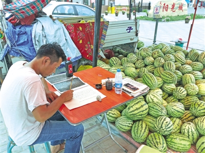 <p>　　“西瓜哥”蒋海涛在西瓜摊前练习书法。　（图片由网友提供）</p>
