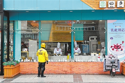 <p>　　银川市王府井百货广场一家蛋糕店外，外卖小哥在等待取餐。</p>